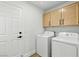 Laundry room featuring a washer, dryer, and overhead cabinets at 2105 Madagascar Ln, Las Vegas, NV 89117