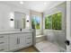 Modern main bathroom featuring a dual vanity with white countertops, a walk-in shower and a window at 2105 Madagascar Ln, Las Vegas, NV 89117