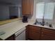 Well-lit kitchen featuring oak cabinets, a breakfast bar, and laminate floors at 2243 Aspen Mirror Way # 102, Laughlin, NV 89029