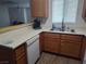 Well-lit kitchen featuring oak cabinets, a breakfast bar, and laminate floors at 2243 Aspen Mirror Way # 102, Laughlin, NV 89029