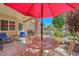 Charming courtyard patio with red umbrella providing shade for an outdoor dining set at 2456 Desert Butte Dr, Las Vegas, NV 89134