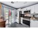Modern kitchen featuring stainless steel appliances, white cabinets, and a sliding glass door to the patio at 2456 Desert Butte Dr, Las Vegas, NV 89134