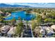 Beautiful aerial view of community homes surrounding a tranquil lake with mountain views at 2512 Huber Heights Dr, Las Vegas, NV 89128