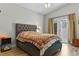 Cozy bedroom with a tufted headboard, patterned quilt, and outdoor access at 2512 Huber Heights Dr, Las Vegas, NV 89128