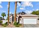 Charming single-story home featuring a two-car garage and desert landscaping under a blue sky at 2512 Huber Heights Dr, Las Vegas, NV 89128