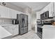 Bright kitchen with stainless steel appliances, ample white cabinetry, and a tiled floor provides a modern and efficient space at 2512 Huber Heights Dr, Las Vegas, NV 89128