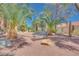 Spacious backyard featuring mature palm trees, decorative rock, and a comfortable bench at 2723 Seabridge Dr, Las Vegas, NV 89121