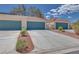 Home exterior with a two-car garage, nicely landscaped grounds, and a tiled roof at 2723 Seabridge Dr, Las Vegas, NV 89121