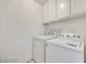 Laundry room featuring a white washer and dryer with overhead cabinets at 2723 Seabridge Dr, Las Vegas, NV 89121