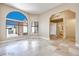 Open concept living room featuring large arched window, travertine floors and chandelier at 2723 Seabridge Dr, Las Vegas, NV 89121