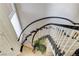 Elegant curved staircase with white spindles and black handrail, flooded with natural light at 3111 Lido Isle Ct, Las Vegas, NV 89117