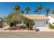 Charming single-story home with desert landscaping, tile roof, and a two-car garage surrounded by mature palm trees at 3414 Drescina Way, North Las Vegas, NV 89031