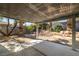 Covered patio overlooking desert-landscaped backyard with rock features, and mature trees at 3414 Drescina Way, North Las Vegas, NV 89031