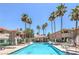 Community pool surrounded by palm trees, lounge chairs, and well-maintained buildings at 370 Manti Pl # 21, Henderson, NV 89014