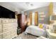Comfortable bedroom with a big TV screen, a window with yellow curtains and big closet at 3773 Blake Canyon Dr, North Las Vegas, NV 89032