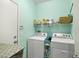 Bright laundry room includes a full sized washer, dryer, and shelving for storage at 3773 Blake Canyon Dr, North Las Vegas, NV 89032
