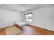 Minimal bedroom with a twin mattress, window view, and worn hardwood flooring at 4036 Nightingale Ct, Las Vegas, NV 89107