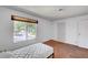 Simple bedroom featuring a twin bed, large window, and worn hardwood floors at 4036 Nightingale Ct, Las Vegas, NV 89107