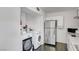 A well-lit laundry room with a washer, dryer, refrigerator, and overhead cabinets at 4036 Nightingale Ct, Las Vegas, NV 89107