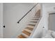 Staircase with hardwood steps, white risers, and a black handrail at 4036 Nightingale Ct, Las Vegas, NV 89107