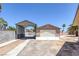 Large backyard featuring a detached garage, metal awning, concrete wall, and desert landscaping at 4458 El Quinta Ct, Las Vegas, NV 89121