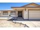 Close up view of a single-story home featuring desert landscaping and a two-car garage at 4458 El Quinta Ct, Las Vegas, NV 89121