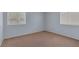 Bright bedroom with beige carpet, white trim, and two windows at 4784 El Escorial Dr, Las Vegas, NV 89121