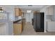 Galley kitchen with granite countertops, stainless steel appliances, and adjacent laundry area at 4784 El Escorial Dr, Las Vegas, NV 89121