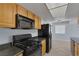 Bright kitchen featuring wood cabinets, black appliances, and tile flooring, with an adjacent dining area at 4784 El Escorial Dr, Las Vegas, NV 89121