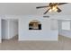 Open-concept living space with tile floors, ceiling fan, and a kitchen view through a serving hatch at 4784 El Escorial Dr, Las Vegas, NV 89121