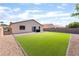 Well-maintained backyard featuring an artificial lawn, a patio, and secure fencing for privacy at 5009 Peaceful Pond Ave, Las Vegas, NV 89131