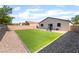 Beautiful backyard with lush artificial turf, rockscape, and block wall surround at 5009 Peaceful Pond Ave, Las Vegas, NV 89131