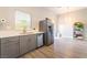 Bright kitchen features stainless steel appliances, white countertops, grey cabinetry, and wood-look flooring at 5009 Peaceful Pond Ave, Las Vegas, NV 89131