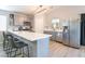 Modern kitchen featuring gray cabinetry, quartz countertops, stainless steel appliances, and a breakfast bar at 5009 Peaceful Pond Ave, Las Vegas, NV 89131