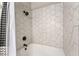 Modern bathtub and shower combo featuring clean white walls, decorative tiling, and matte black hardware at 5009 Peaceful Pond Ave, Las Vegas, NV 89131