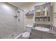 Bathroom featuring a marble tiled shower with a neutral vanity and gray cabinets at 5093 Sun Valley Dr, Las Vegas, NV 89122
