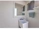 Compact utility sink area with a mirror and open shelving maximizes limited space at 5093 Sun Valley Dr, Las Vegas, NV 89122