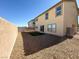 View of the backyard with gravel landscaping, artificial turf, and a block wall at 5308 Hollyridge St, North Las Vegas, NV 89081