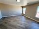 Bright bedroom featuring modern wood-look flooring, two windows, and neutral colored walls at 5308 Hollyridge St, North Las Vegas, NV 89081