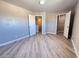 Large bedroom featuring wood-look flooring, neutral paint, and a view of two doorways at 5308 Hollyridge St, North Las Vegas, NV 89081