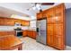 Charming kitchen showcasing stainless steel appliances and light wood cabinetry, complemented by tile flooring at 5673 Coaldale Pl, Las Vegas, NV 89110