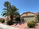 Charming home features a two-car garage, mature palm trees, and lush, low-maintenance desert landscaping at 5929 Gentle Creek Ln, North Las Vegas, NV 89031