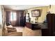 Office featuring built-in dark brown desk, shelving, picture window, and light wood laminate floors at 5929 Gentle Creek Ln, North Las Vegas, NV 89031