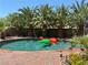 Sparkling pool surrounded by lush palm trees and a brick patio, perfect for relaxing and entertaining at 5929 Gentle Creek Ln, North Las Vegas, NV 89031
