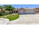 Inviting single-story home with a three-car garage and a lush green lawn at 6307 Dusty Mile Ct, North Las Vegas, NV 89031