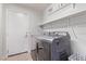 Clean laundry room with washer, dryer, and storage shelving at 6307 Dusty Mile Ct, North Las Vegas, NV 89031