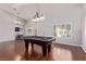 Bright living area with pool table, pendant lights, plantation shutters, and wood flooring at 6307 Dusty Mile Ct, North Las Vegas, NV 89031