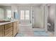 Bright bathroom with a dual sink vanity, soaking tub, walk-in shower, and modern fixtures at 6307 Dusty Mile Ct, North Las Vegas, NV 89031