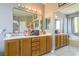 Bright bathroom featuring double sinks, vanity, large mirror, and a sliding door closet at 7537 Splashing Rock Dr, Las Vegas, NV 89131