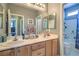 Bathroom featuring dual sinks, wood cabinets, and a shower-tub combination at 7537 Splashing Rock Dr, Las Vegas, NV 89131